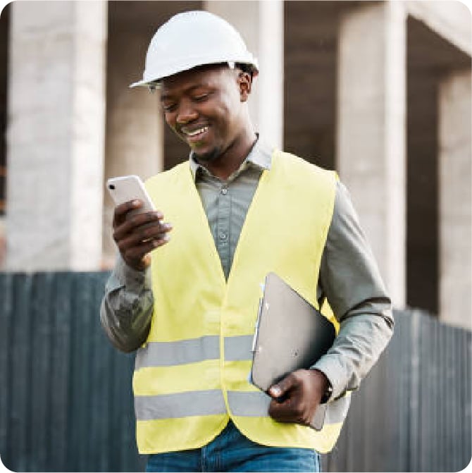 Smiling construction worker on his phone.